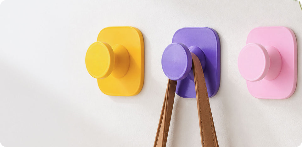 Ganci da parete gialli, viola e rosa stampati con filamento PETG